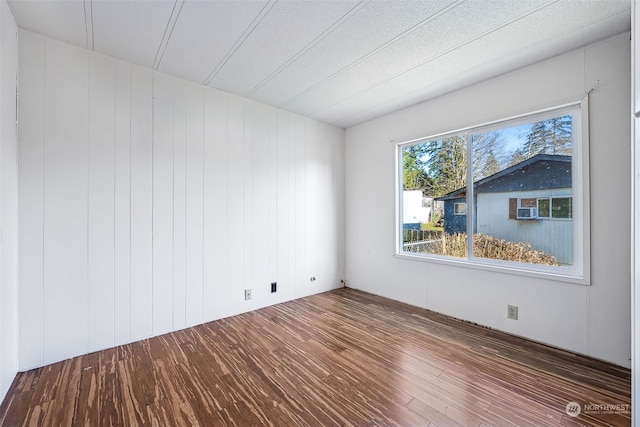 unfurnished room with dark wood-type flooring