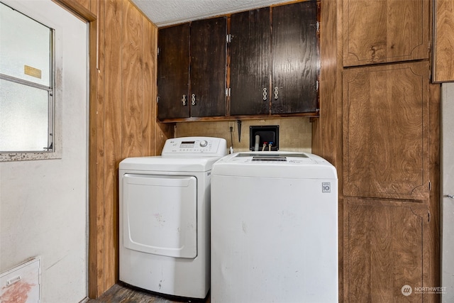 clothes washing area with cabinets and washing machine and clothes dryer