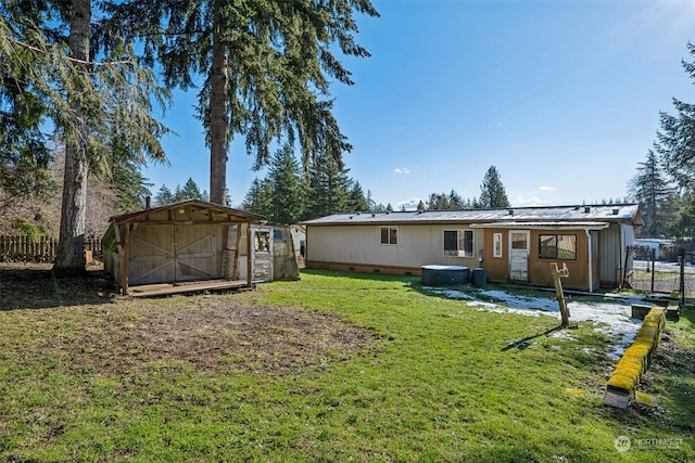 rear view of property featuring a storage shed and a lawn