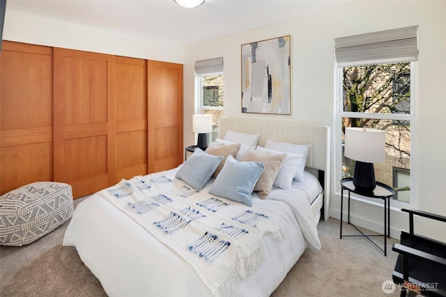 bedroom featuring light carpet and a closet