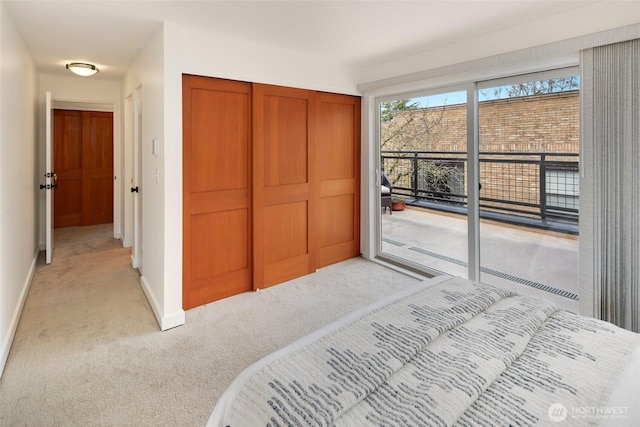 carpeted bedroom featuring a closet and access to outside