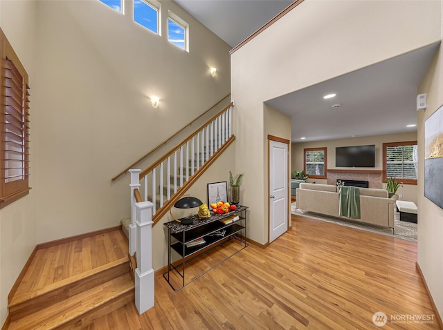 stairs with hardwood / wood-style flooring and a towering ceiling