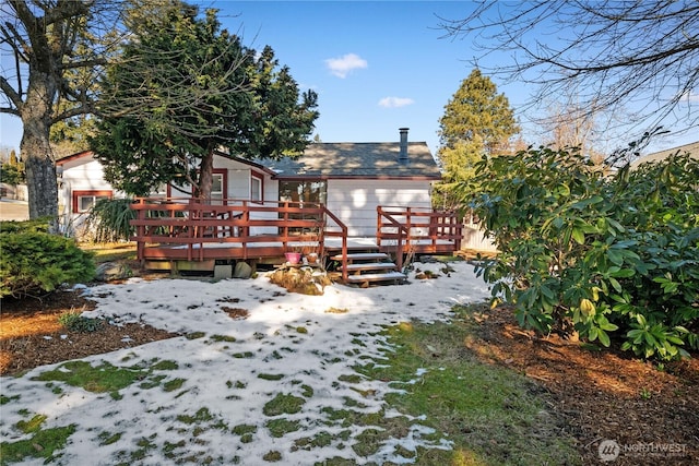 snow covered house with a deck