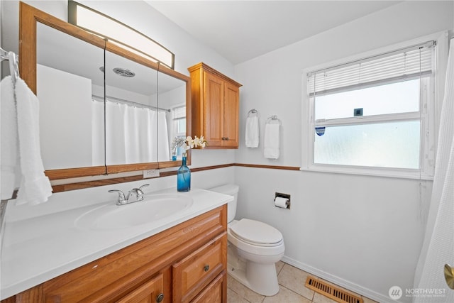 bathroom featuring vanity, tile patterned floors, and toilet