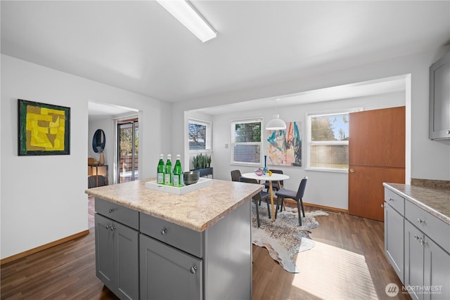 kitchen featuring gray cabinets, a kitchen island, and dark hardwood / wood-style flooring