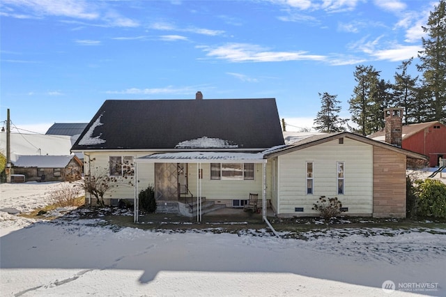 view of snow covered back of property