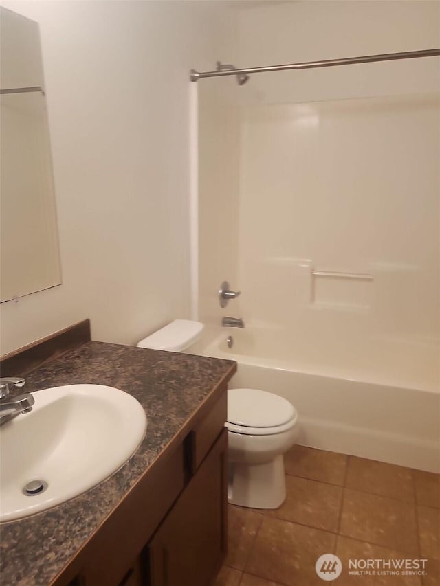 full bathroom featuring vanity, tile patterned floors, toilet, and washtub / shower combination