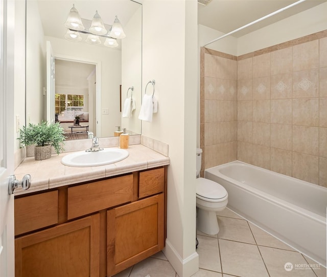 full bathroom featuring vanity, tile patterned floors, toilet, and tiled shower / bath