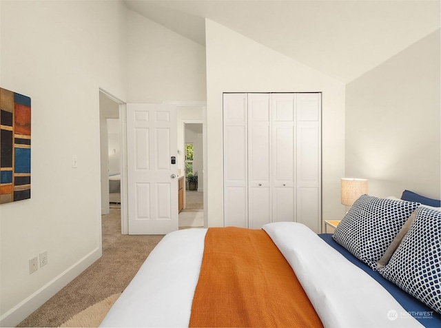 bedroom with light carpet, lofted ceiling, and a closet