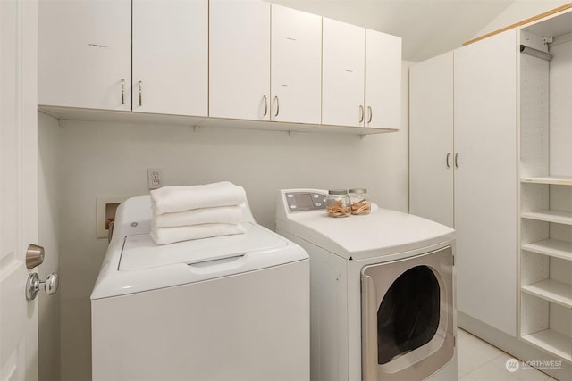 laundry area featuring washing machine and dryer and cabinets