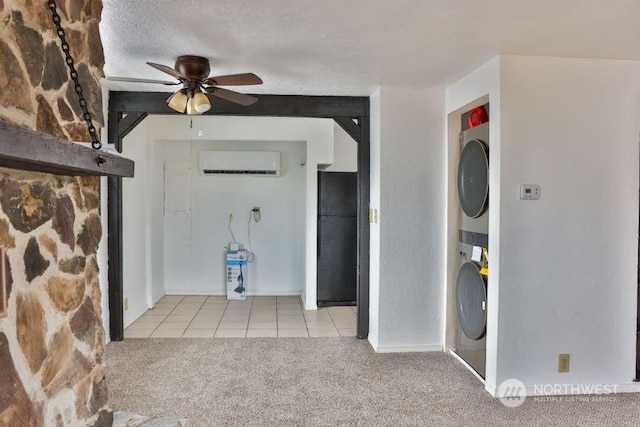 interior space featuring a wall mounted AC, stacked washer and clothes dryer, light colored carpet, ceiling fan, and a textured ceiling