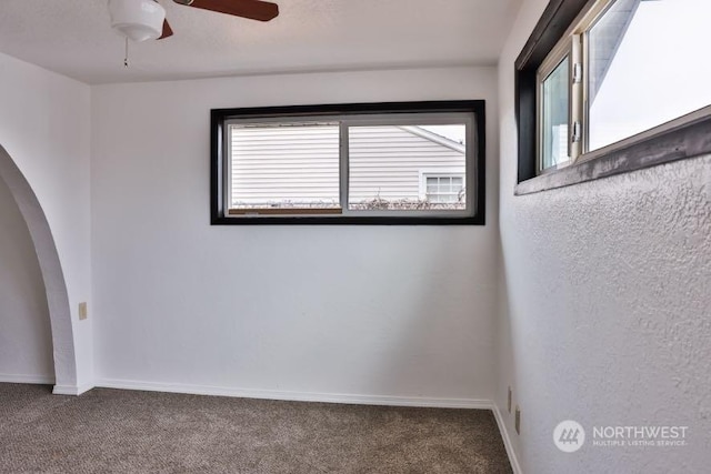 carpeted spare room featuring ceiling fan