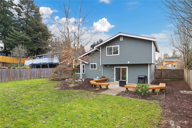 back of house featuring a wooden deck and a yard