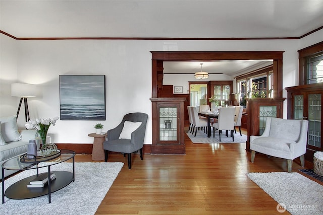 living room with light wood-style floors and ornamental molding