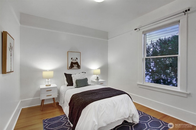 bedroom featuring baseboards and wood finished floors