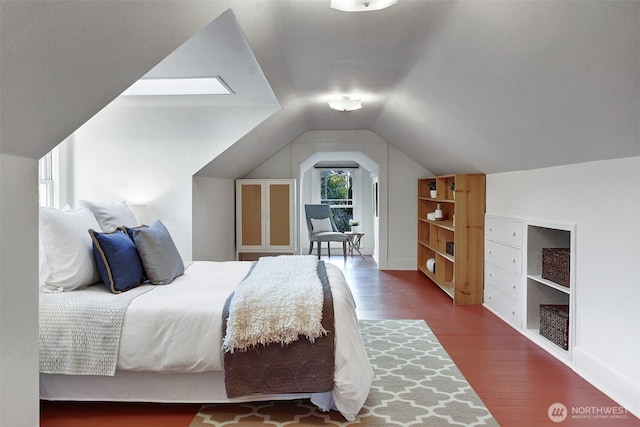 bedroom with vaulted ceiling and wood finished floors