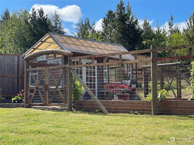 view of poultry coop featuring a lawn and fence