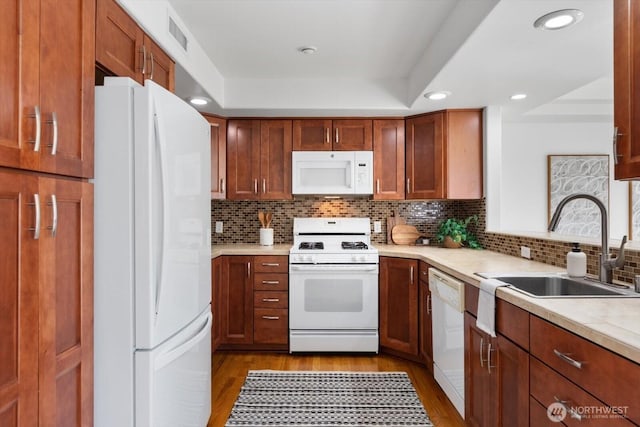 kitchen featuring tasteful backsplash, white appliances, light hardwood / wood-style floors, and sink