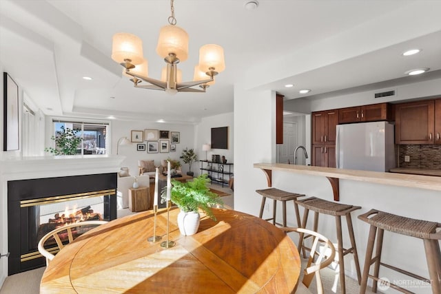 dining room with an inviting chandelier and a multi sided fireplace