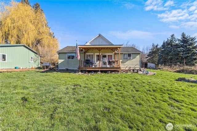 back of property with a wooden deck and a lawn