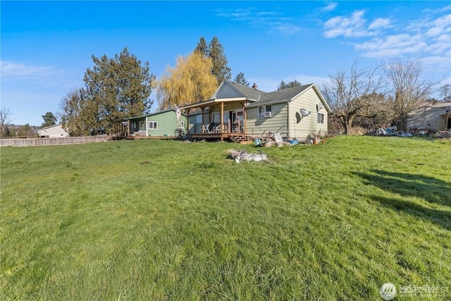 back of house featuring a wooden deck and a yard