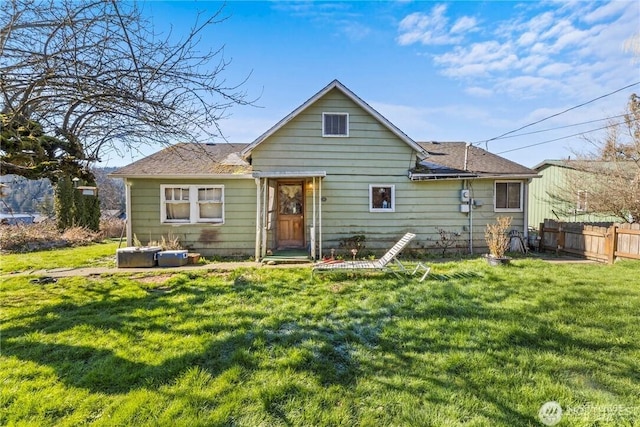 rear view of house featuring a lawn