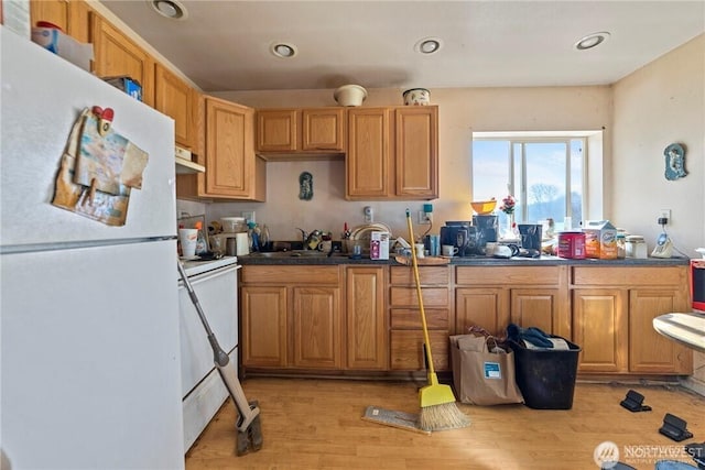 kitchen featuring white appliances, sink, and light wood-type flooring