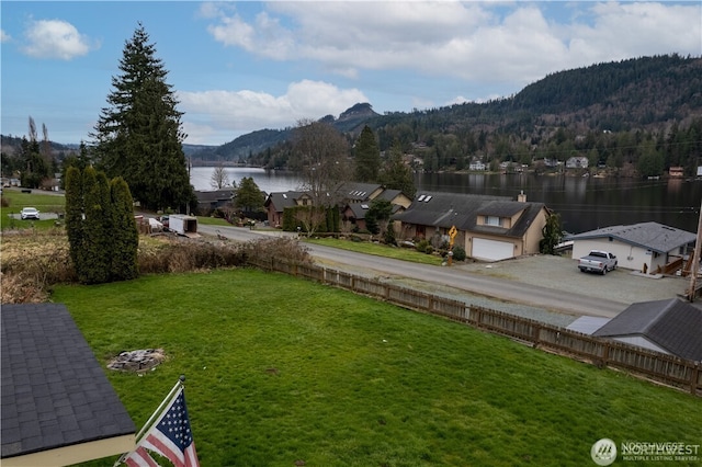 view of yard with a garage and a water and mountain view