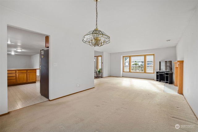 unfurnished living room with light colored carpet and a chandelier