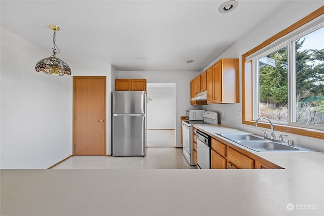 kitchen featuring stainless steel appliances, sink, and hanging light fixtures