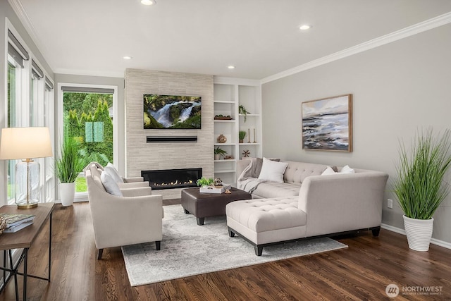 living area with ornamental molding, a fireplace, dark wood finished floors, and built in shelves