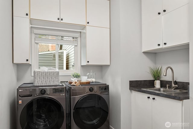 laundry area with cabinet space, separate washer and dryer, and a sink