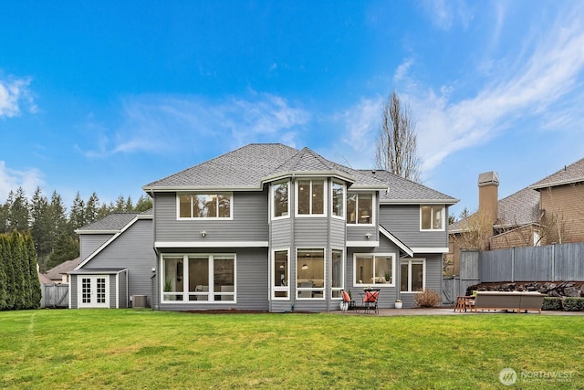 rear view of house with a lawn, a patio, a jacuzzi, fence, and central AC