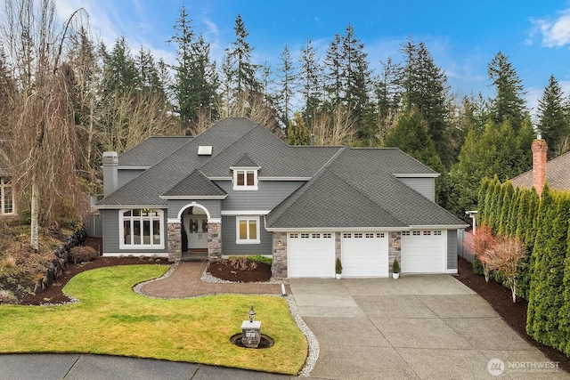 traditional-style home featuring a garage, stone siding, concrete driveway, roof with shingles, and a front lawn