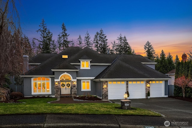 view of front of property featuring aphalt driveway, stone siding, a front lawn, and an attached garage