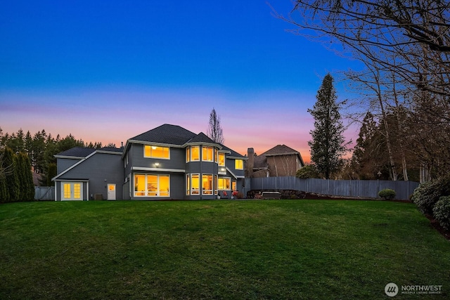 back of property featuring a lawn, fence private yard, and a balcony