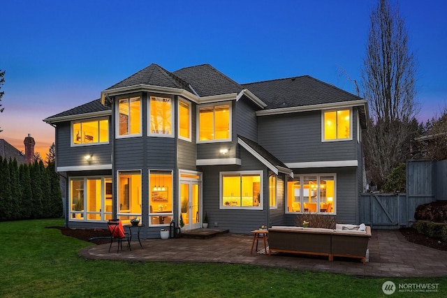 rear view of house with a gate, a patio area, a yard, and outdoor lounge area