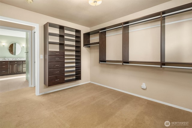 walk in closet with light tile patterned floors and light colored carpet