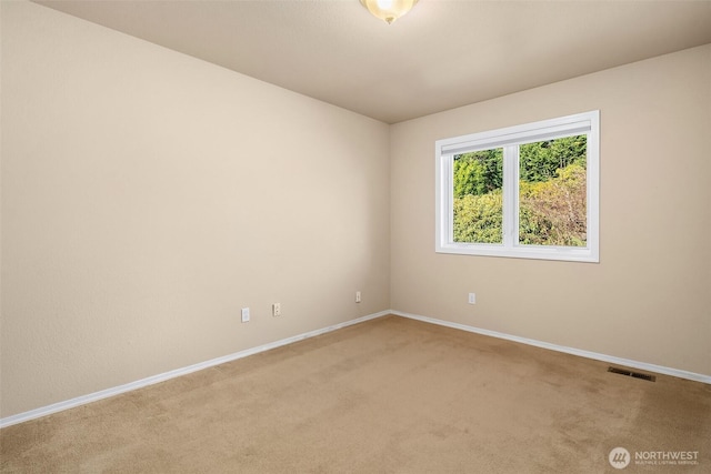 empty room featuring carpet floors, baseboards, and visible vents