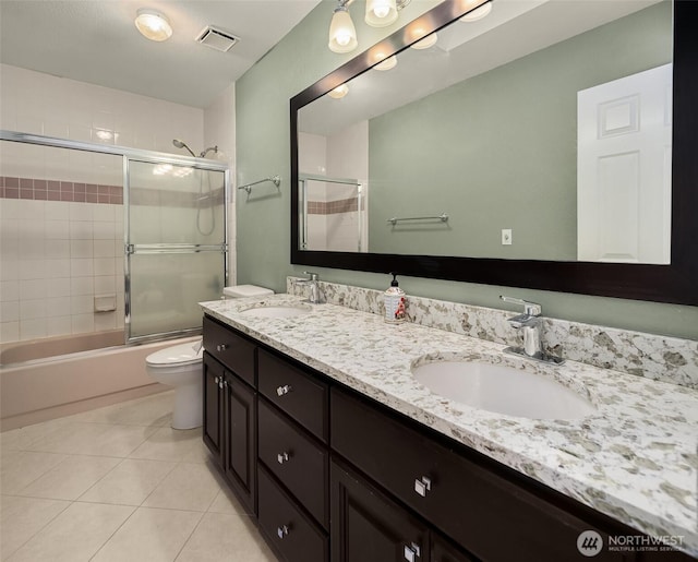 bathroom featuring double vanity, tile patterned flooring, visible vents, and a sink