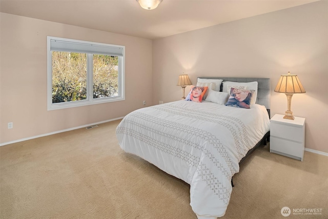 bedroom featuring baseboards, visible vents, and light colored carpet