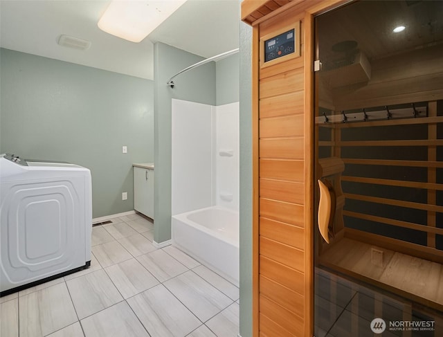 full bath with bathing tub / shower combination, washer / clothes dryer, a sauna, tile patterned flooring, and baseboards