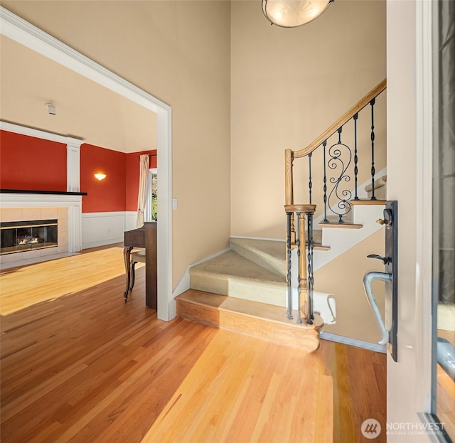 stairway featuring a fireplace and wood finished floors