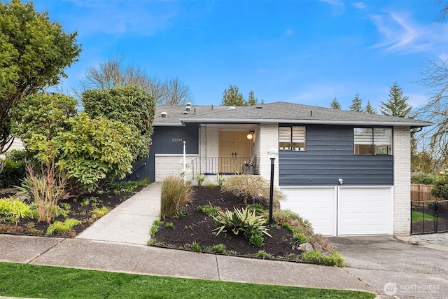 ranch-style home featuring a garage, brick siding, driveway, and fence