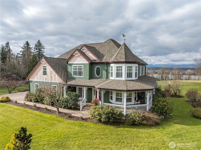 view of front of property featuring covered porch and a front lawn