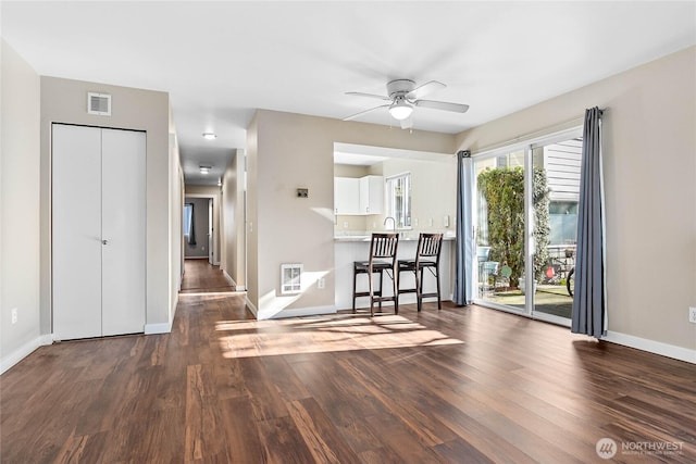 unfurnished dining area featuring dark hardwood / wood-style flooring, sink, and ceiling fan