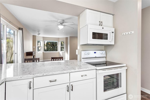 kitchen with white cabinetry, white appliances, ceiling fan, and light stone counters