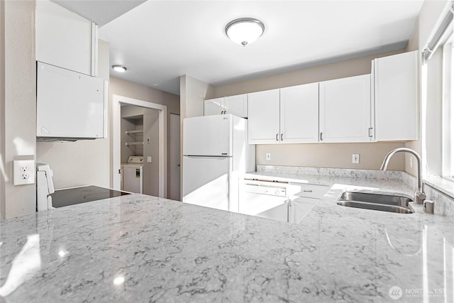 kitchen featuring washer / dryer, sink, white cabinetry, white appliances, and light stone countertops