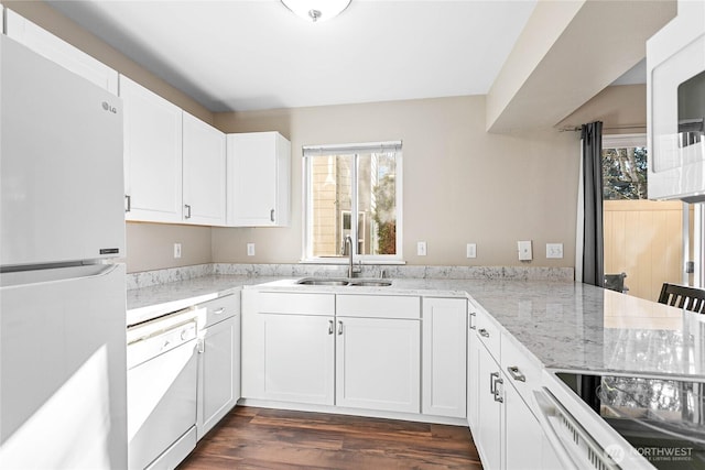 kitchen with sink, white appliances, dark hardwood / wood-style floors, light stone counters, and white cabinets