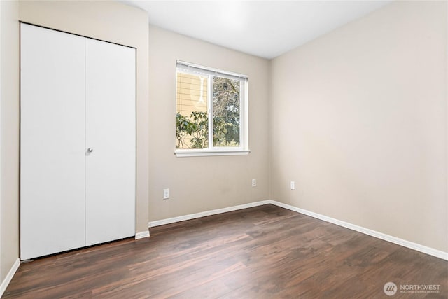 unfurnished bedroom featuring dark wood-type flooring and a closet